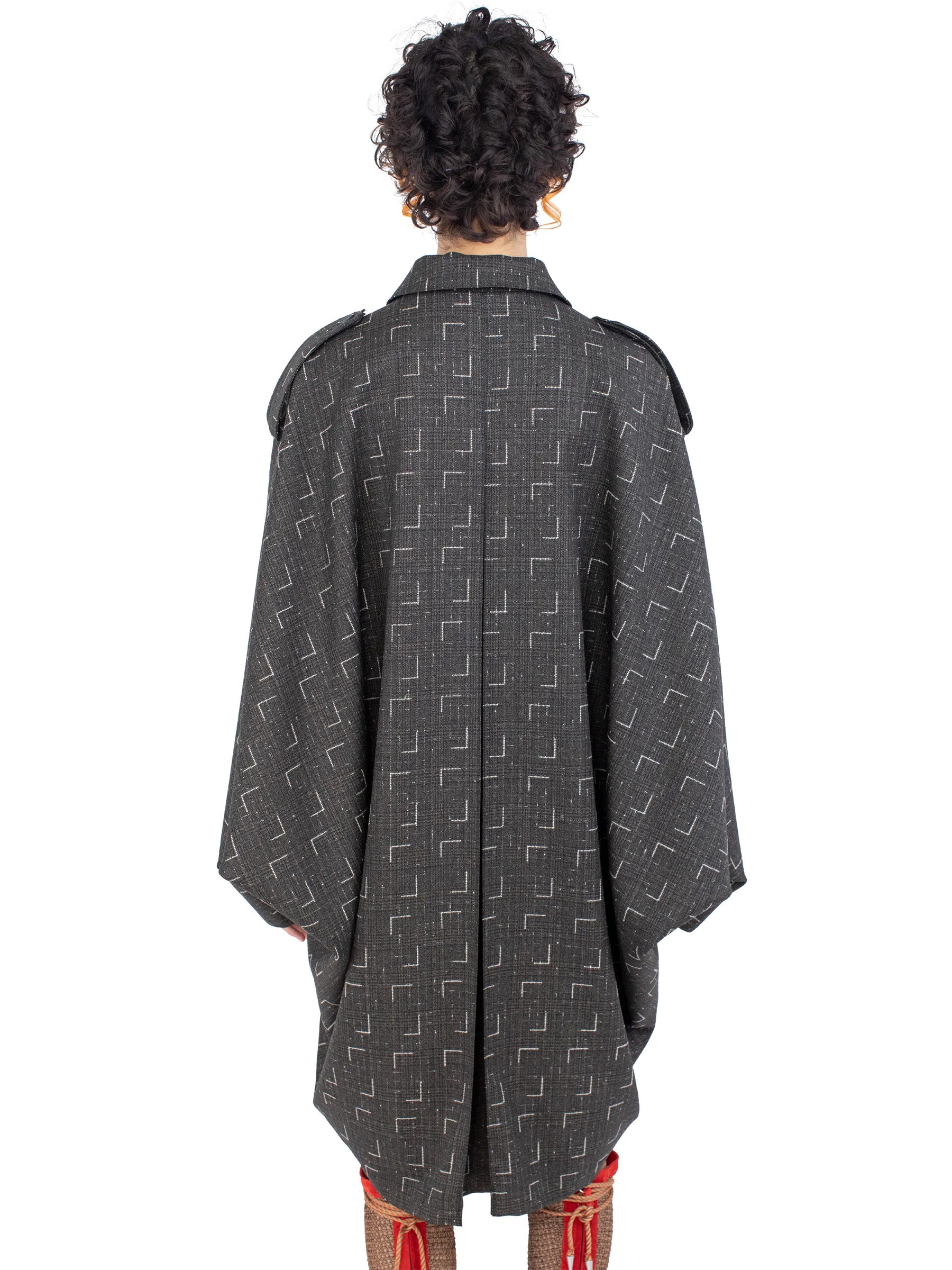 Detail view of the draped silhouette and back construction of the Kiko Kostadinov Statsinger Coat.