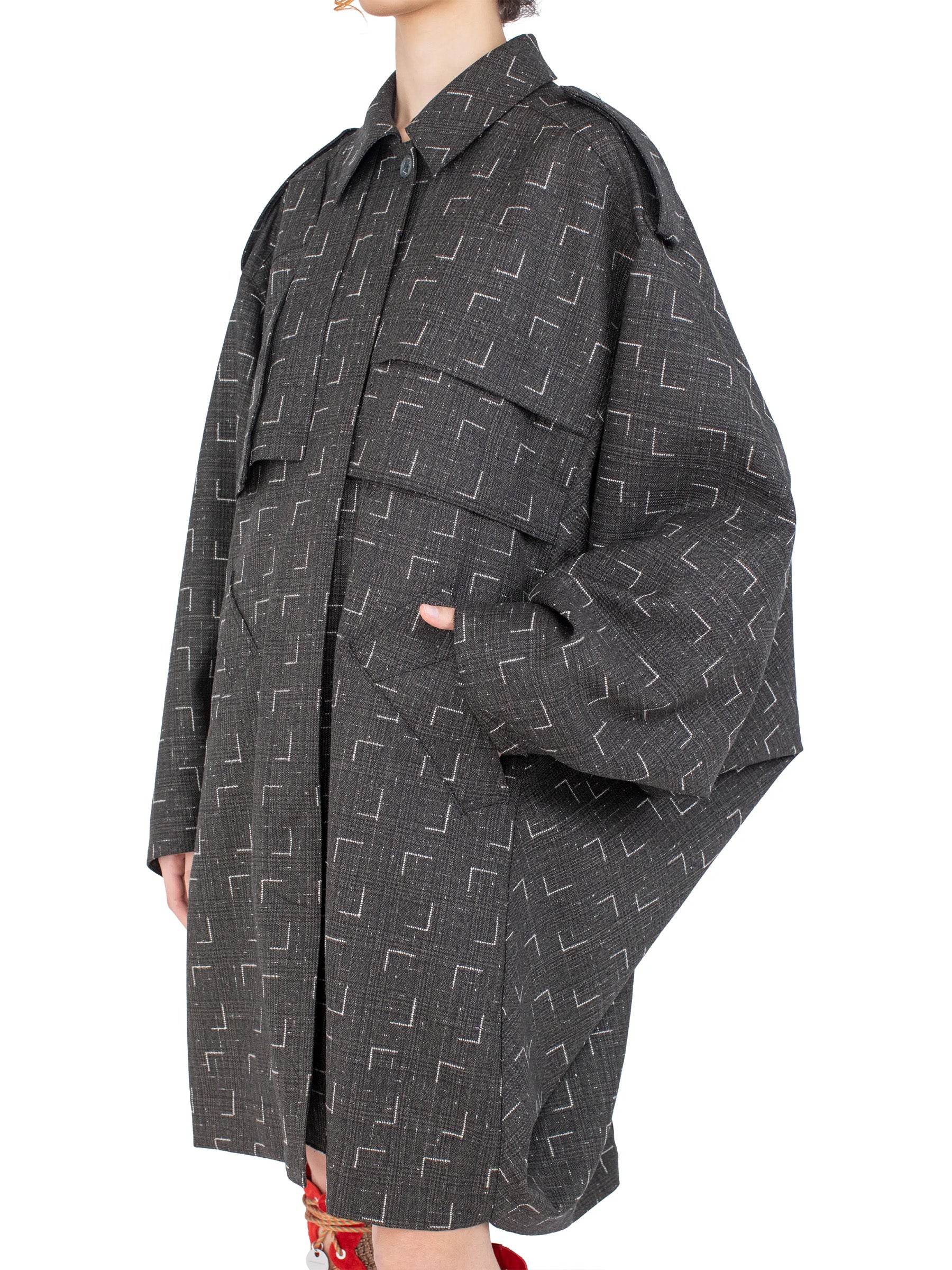 Close-up of the front closure and patterned fabric on the Kiko Kostadinov Statsinger Coat.