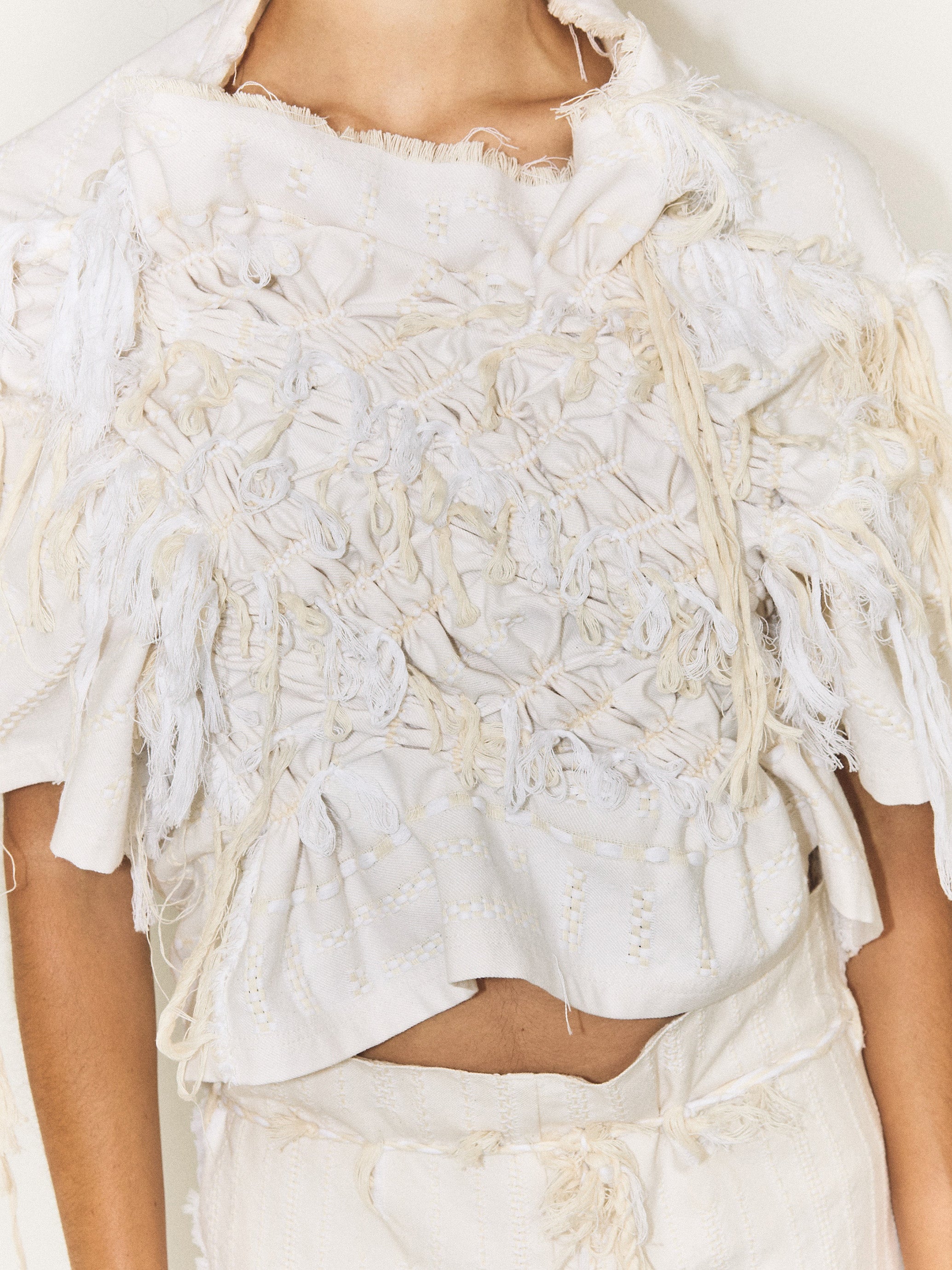 Close up of model wearing the Stem Basket Tee in off-white