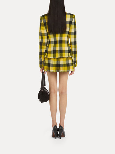 Person wearing a black and yellow checkered outfit from Vivienne Westwood on a light background.
