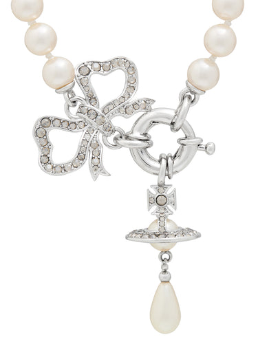 Pearl necklace with a silver bow and orb charm on a white background