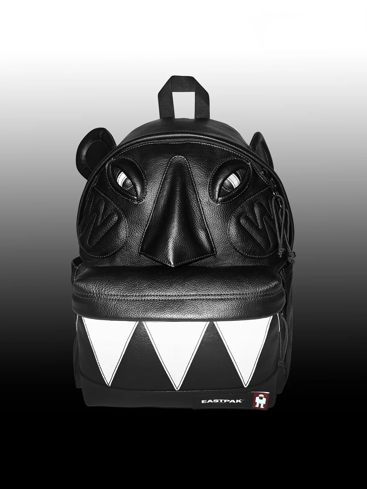 Walter Van Beirendonck Walter Pak'r in Black Faux Leather, front view showing padded eyes, nose, mouth detail and graphic front pocket.