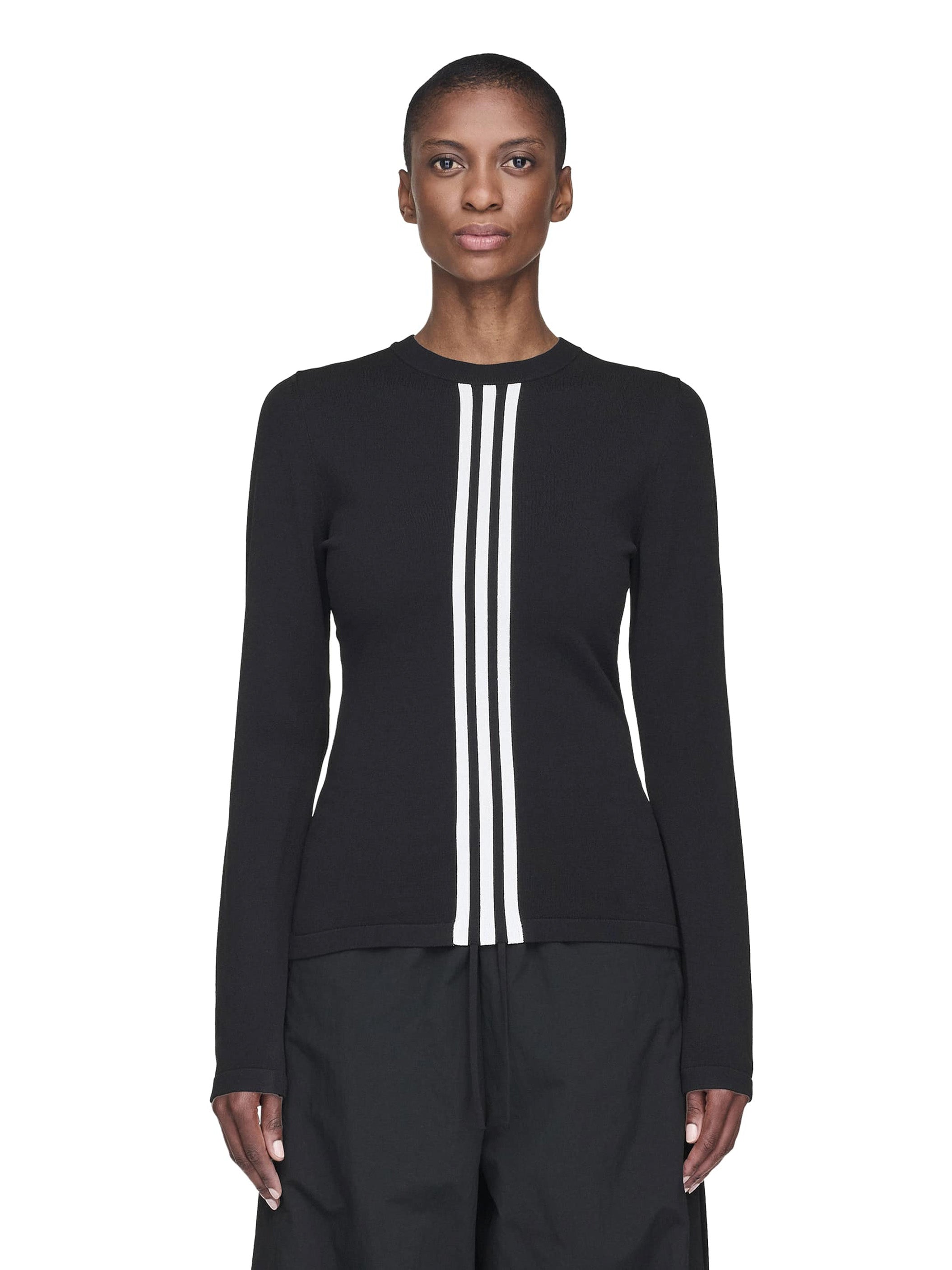 Person wearing a black long-sleeve top with white stripes on a white background