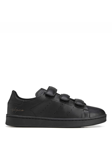 Side packshot of the Y-3 Stan Smith Hook-and-Loop Shoes in Black, showing the black leather upper, hook-and-loop strap closure, and perforated 3-Stripes.