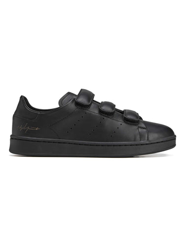 Side packshot of the Y-3 Stan Smith Hook-and-Loop Shoes in Black, showing the black leather upper, hook-and-loop strap closure, and perforated 3-Stripes.
