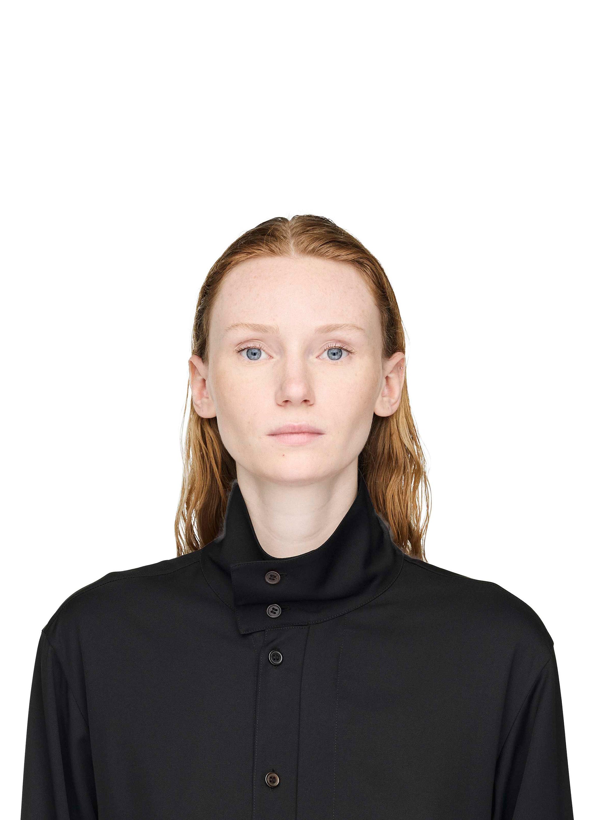 Person wearing a black high-necked garment on a white background
