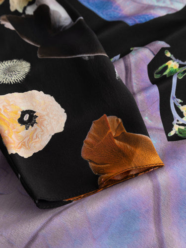 Detail close-up of the Asymmetric Top highlighting the dark floral print, soft fabric texture, and asymmetric seam construction.