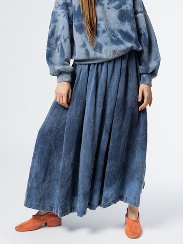 Person wearing a blue tie-dye outfit with a long skirt from Anntian on a white background