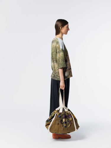 Side view of model wearing the Anntian T-Shirt in Print KL, highlighting the loose silhouette and short sleeves of the donkey on a grass field print t-shirt