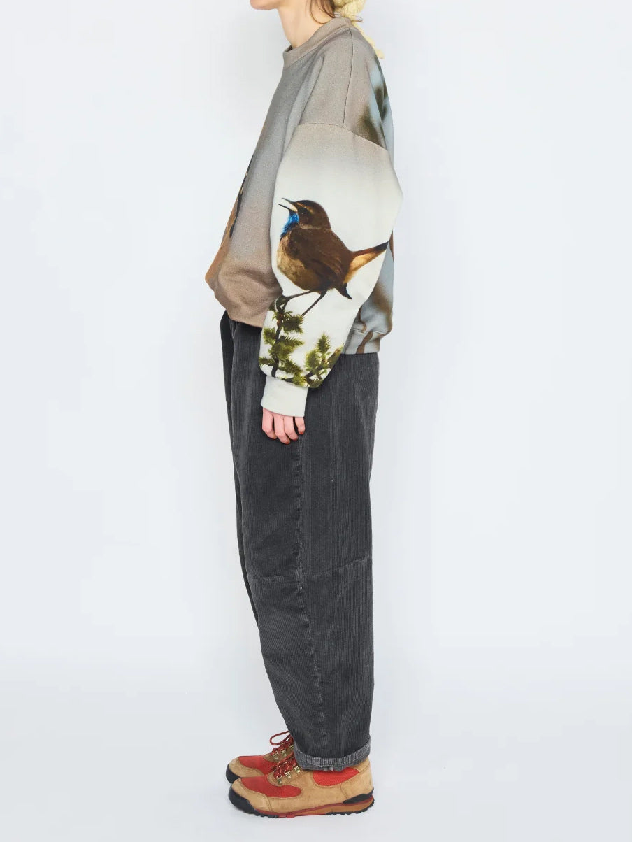 Anntian Unisex Sweater in Print A worn on model from the side, highlighting the dropped shoulder and bird print across the sleeve.