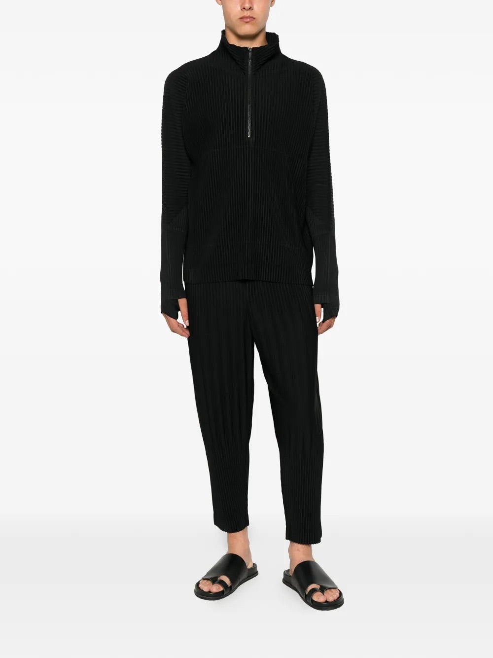 Model wearing Homme Plissé Issey Miyake black pleated pants front view