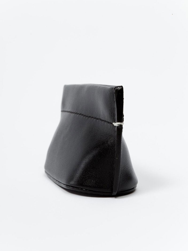 Building Block Coin Dumpling in Black leather, shown from an angled side view highlighting its compact curved shape.