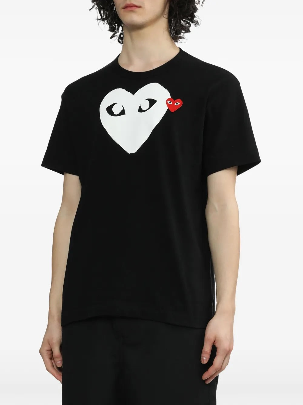 Close-up of model wearing Comme des Garçons Play black Big Heart T-Shirt with large white heart print and red heart chest logo