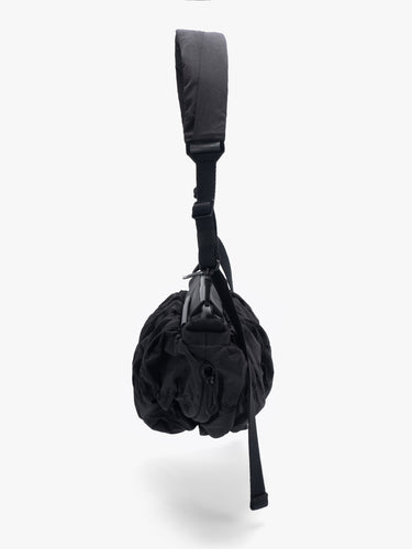 Côte&Ciel Orne Otra Gathered crossbody bag in black, side view highlighting gathered nylon texture and dynamic sculptural design.