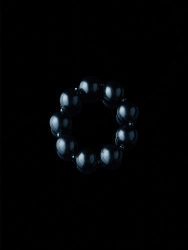 Black and round obsidian bracelet from De Silang on a black background