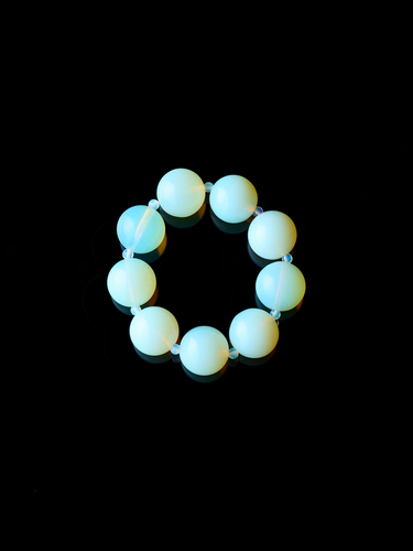Round, opal moon bracelet from De Silang on a black background
