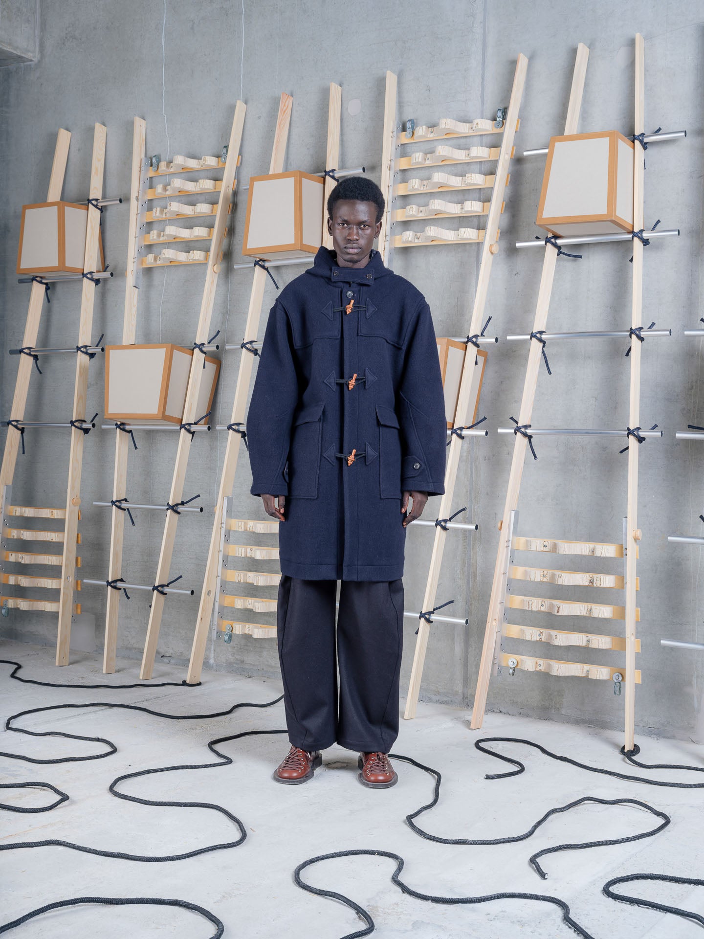 Model wearing Henrik Vibskov Duffle Coat in Navy Duffle front three-quarter view
