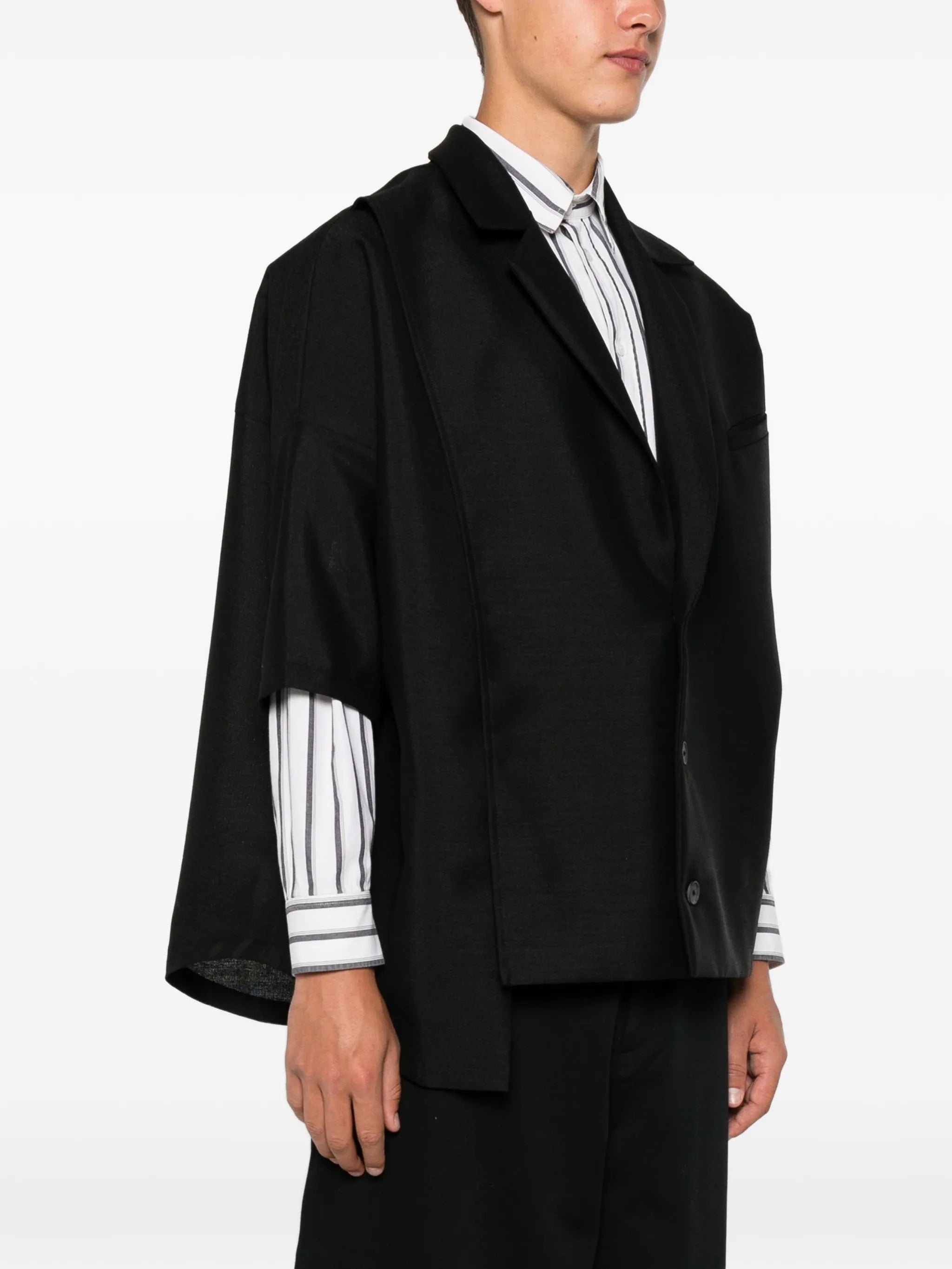 House Of The Very Islands Esra Shirt in Black - front view on model showing notch lapel and chest pocket with trim detail