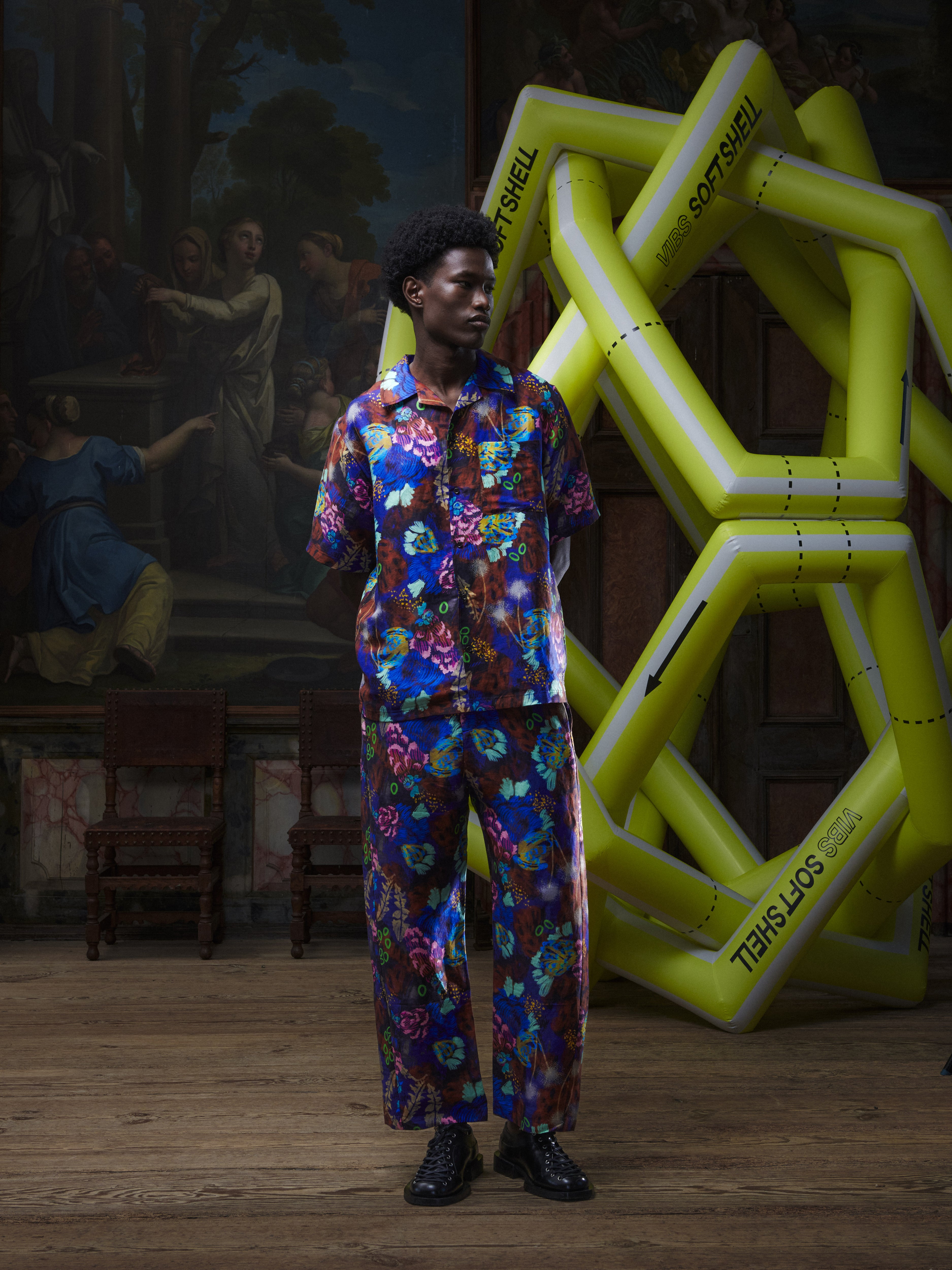 Another front view of the male model wearing the Artist Shirt in Space Chickens from Henrik Vibskov Spring/Summer 2026 Studio Collection, highlighting the unisex fit, bold colourful pattern, and front button closure.