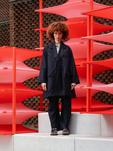 Front view of a model wearing the black Beetle Coat, showing blazer collar, front button closure, and layered detailing.