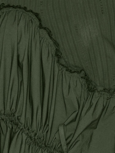 Close-up of the Bon Chalant Dress highlighting the dark green fabric and elastic ruched detailing.