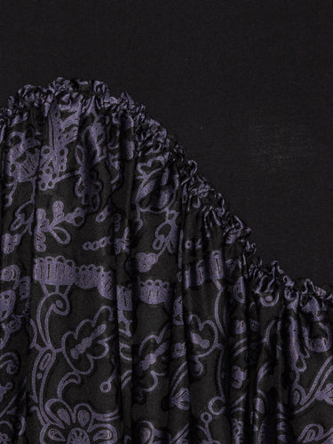 Closeup of Henrik Vibskov Bon Chalant Tee in black, highlighting black and purple floral print and sculptural fabric texture.