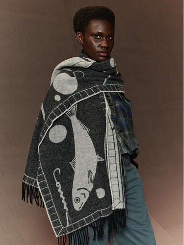 Person wearing a patterned scarf with fish design on a brown background