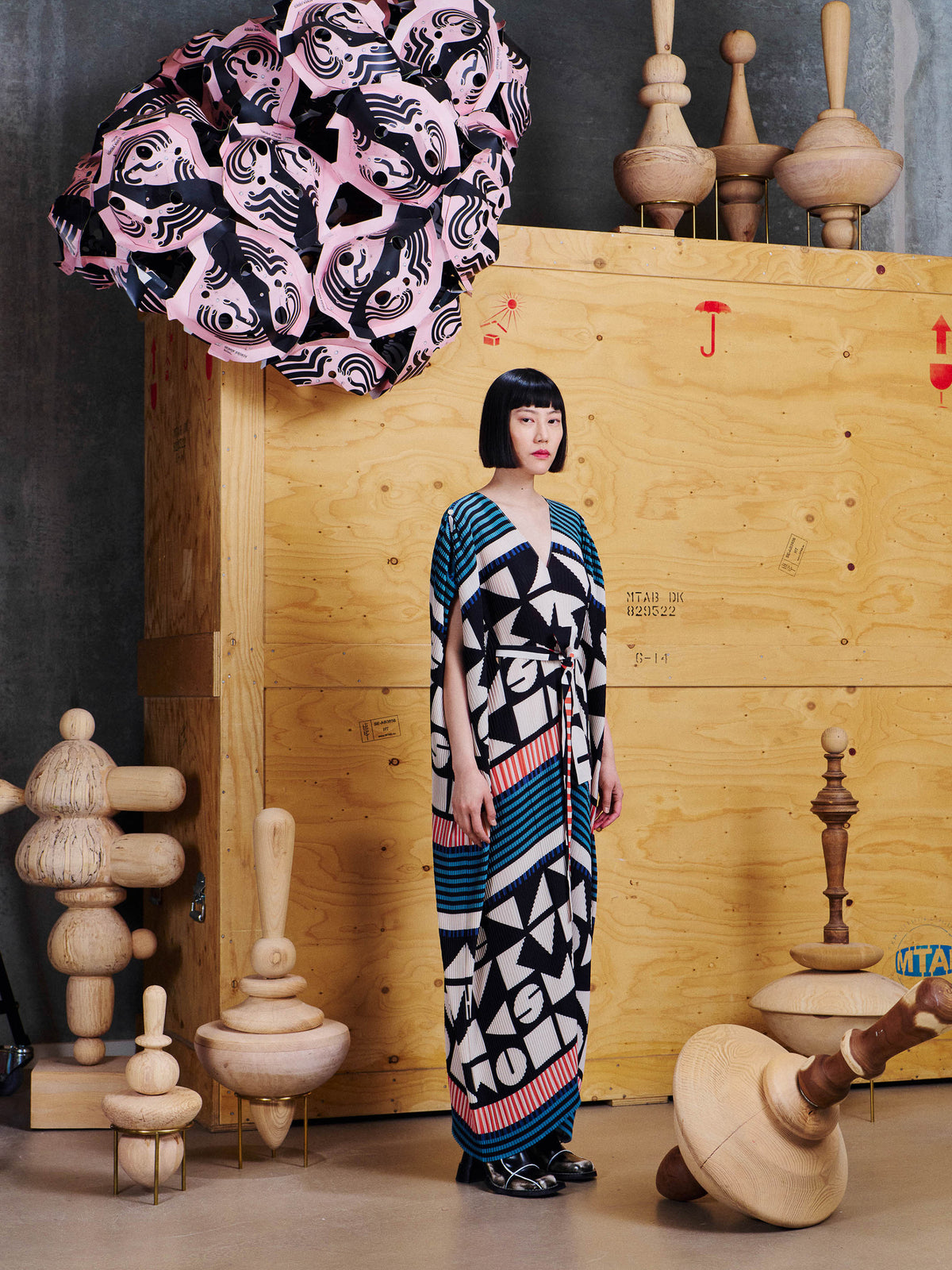 Side view of model wearing Henrik Vibskov Cherry Plisse Kaftan in Vibs In Bobs, showing the long relaxed silhouette and wide sleeves.