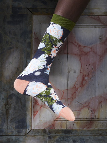 Close-up of a leg wearing the Chicken Socks in Dill Chickens from Henrik Vibskov Spring/Summer 2026 Studio Collection, highlighting the navy base and multicoloured chicken-pattern details.