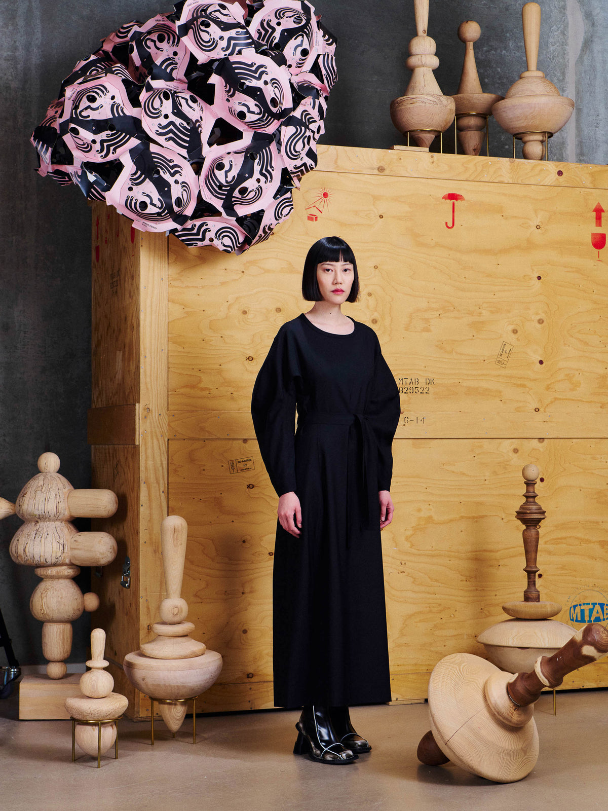 Angled view of model wearing the Henrik Vibskov Crackle Dress in Black, showing the defined waist, sculptural sleeves and flowing skirt.