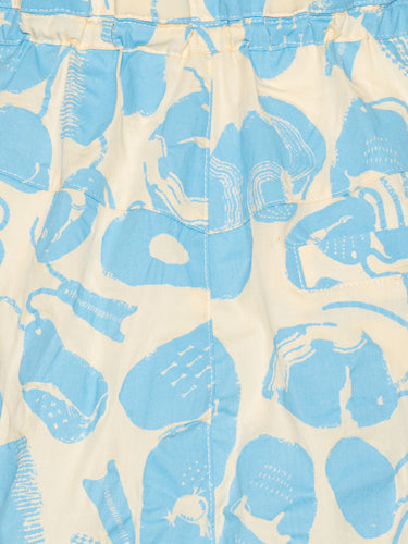 Close-up of the Drawstring Pants in Ecru Amulets, highlighting the blue amulets pattern, off-white fabric, and elastic waistband with drawstring.