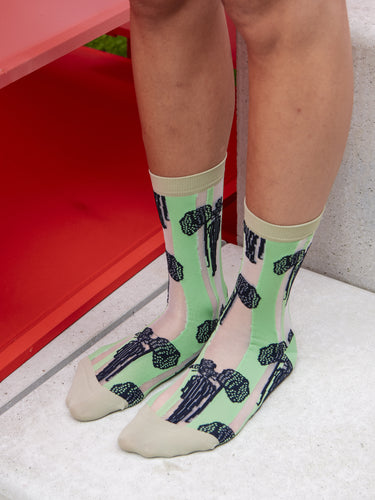 Model wearing Dreamcatcher Socks Femme in Navy Catcher by Henrik Vibskov, tight-fitting striped socks with neon green and white bands, navy dreamcatcher motif and beige accents, styled on legs, Henrik Vibskov Spring/Summer 2026