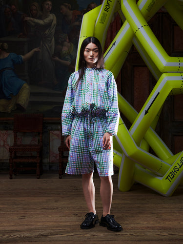 Model wearing the Henrik Vibskov Flat Shirt in Checks Fillé, front view. The model is 167 cm and wears size S, showing the round collar, check pattern, and cropped elastic hem with drawstring.