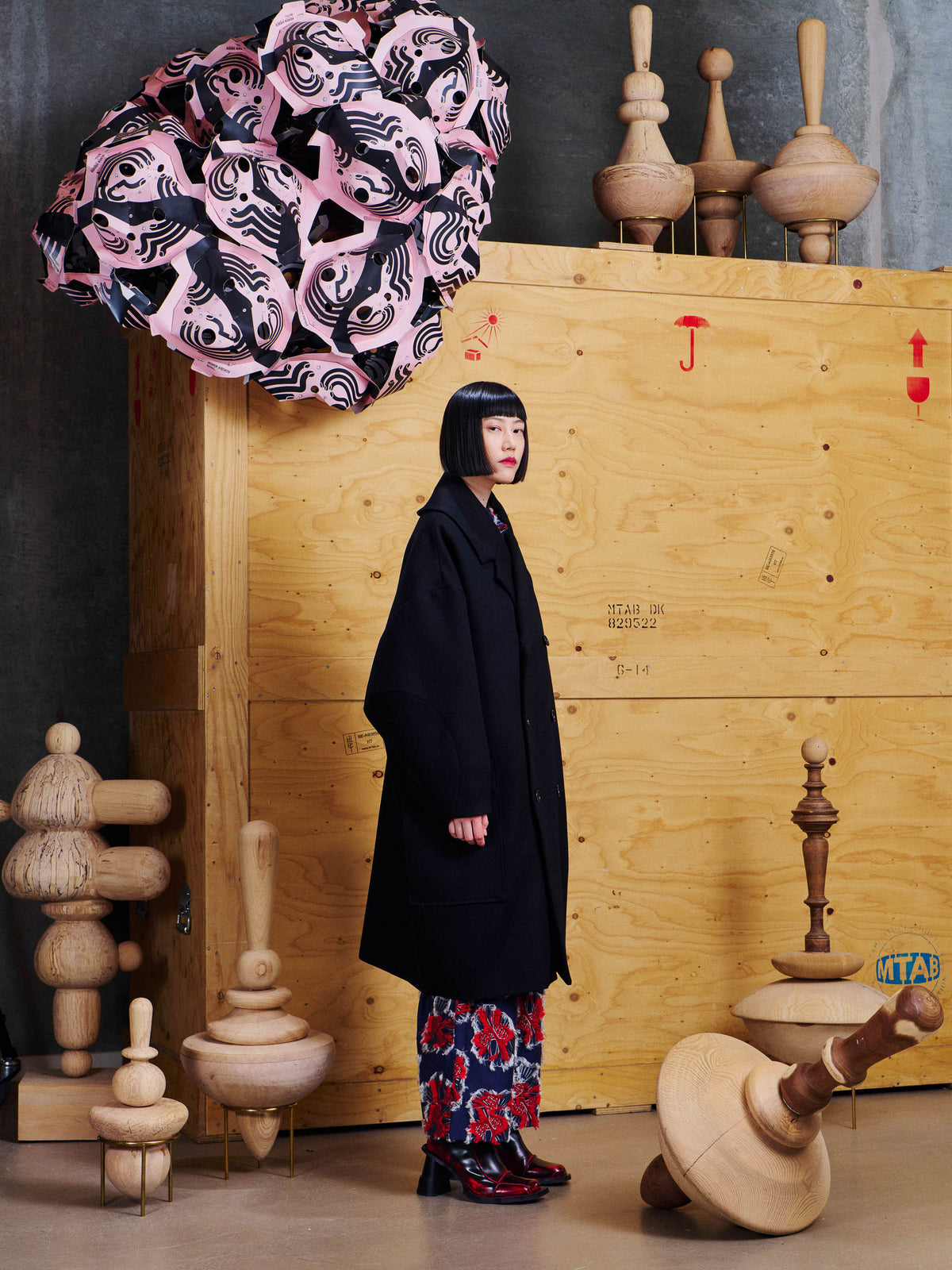 Side view of model wearing the Henrik Vibskov Floating Coat in Black, showing the long length, relaxed proportions and structured collar.