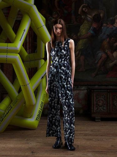 Model wearing the full plissé pants in the bursting-eggs pattern, shown from the front.