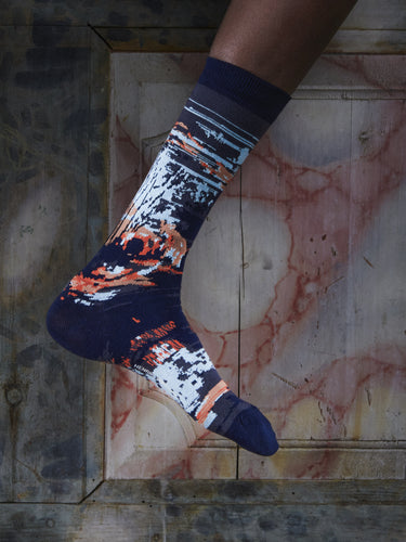 Close-up of a leg wearing the Foxy Socks in Navy Foxy from Henrik Vibskov Spring/Summer 2026 Studio Collection, highlighting the navy colour and fox-pattern detailing.