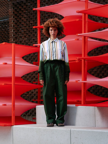 Model wearing the Helmet Pants in Garden Green navy green wide-leg pants with elastic waistband and drawstring, front view – Henrik Vibskov Spring/Summer 2026 Key Collection