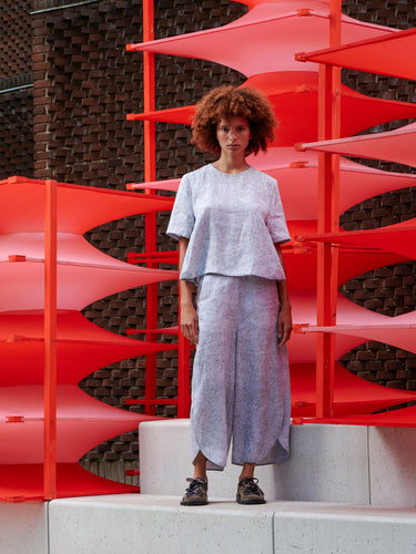 Model wearing the Helmet Top in Bike Helmets grey short sleeve top with subtle texture detail and round neck, front view – Henrik Vibskov Spring/Summer 2026 Key Collection