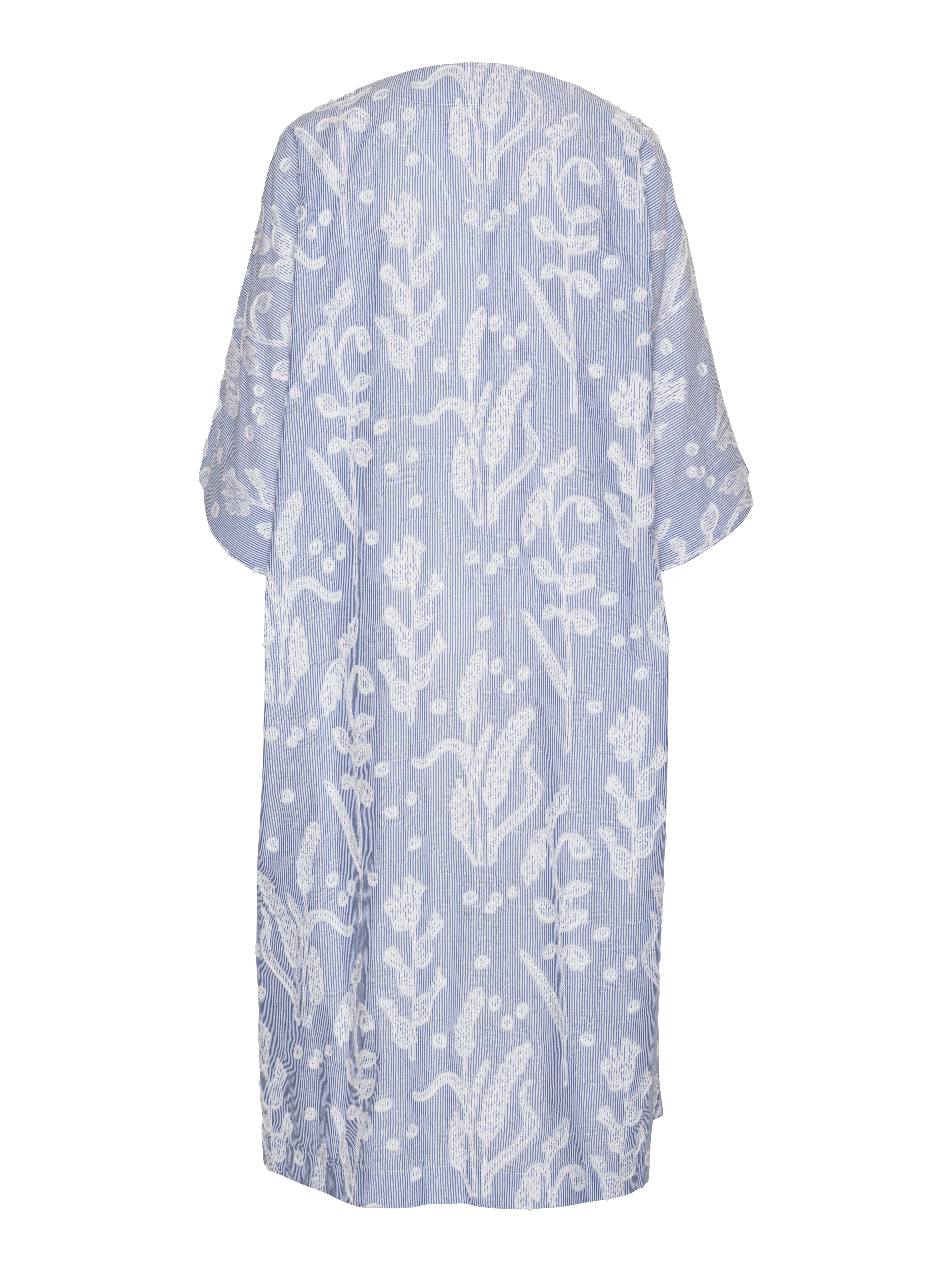 Back view of the Insurance Dress showing the loose fit, short wide sleeves, and textured floral fabric.