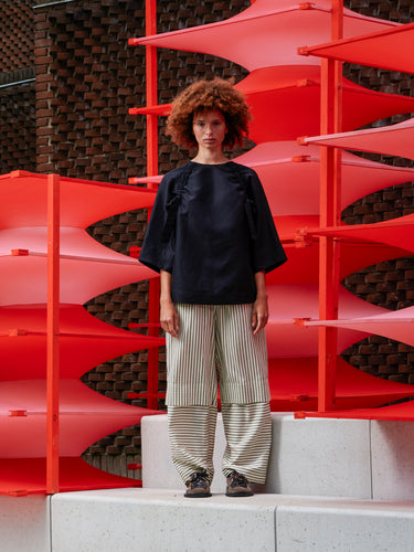 Front view of a model wearing the black Insurance Top, showing the oversized silhouette and round neckline.