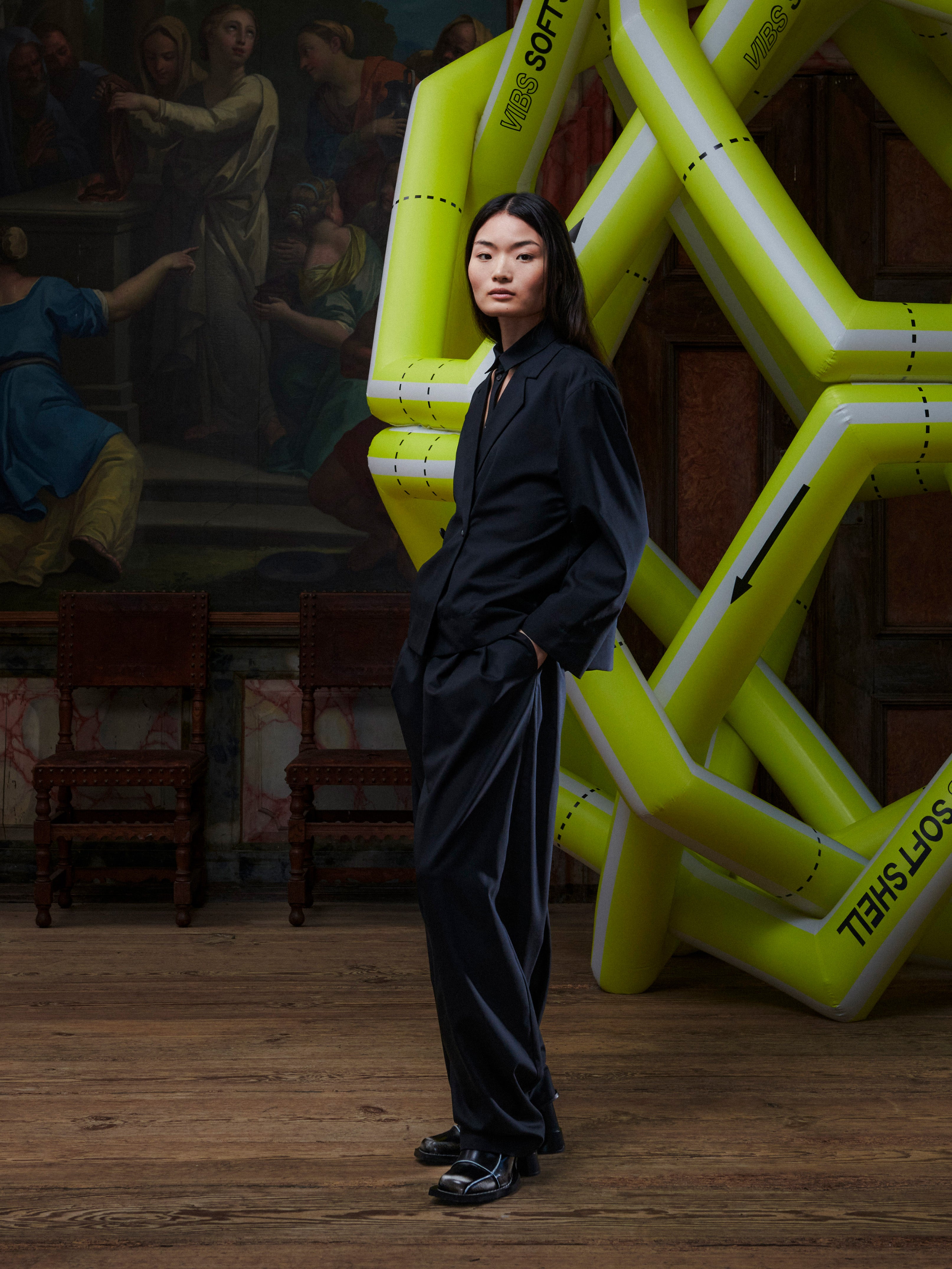 Model wearing the Henrik Vibskov Lonely Sjacket in Tropical Wool, side view, showing the layered construction, straight cropped hem, and tailored profile.