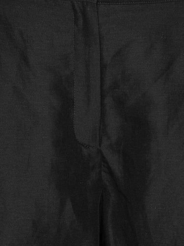 Close-up of the black Tencel-linen fabric highlighting the fluid texture, belt loops and tailored waistband.