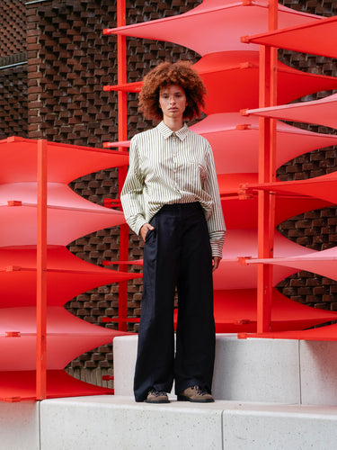 Model wearing Henrik Vibskov Merge Pants in black, shown from the front with relaxed wide-leg fit and clean tailored finish.