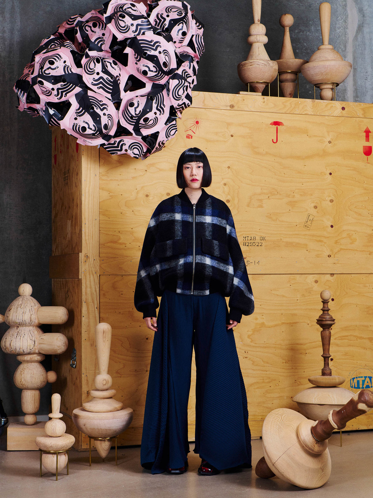 Female model wearing Henrik Vibskov Merry Bomber from the front, styled with wide-leg pleated trousers.