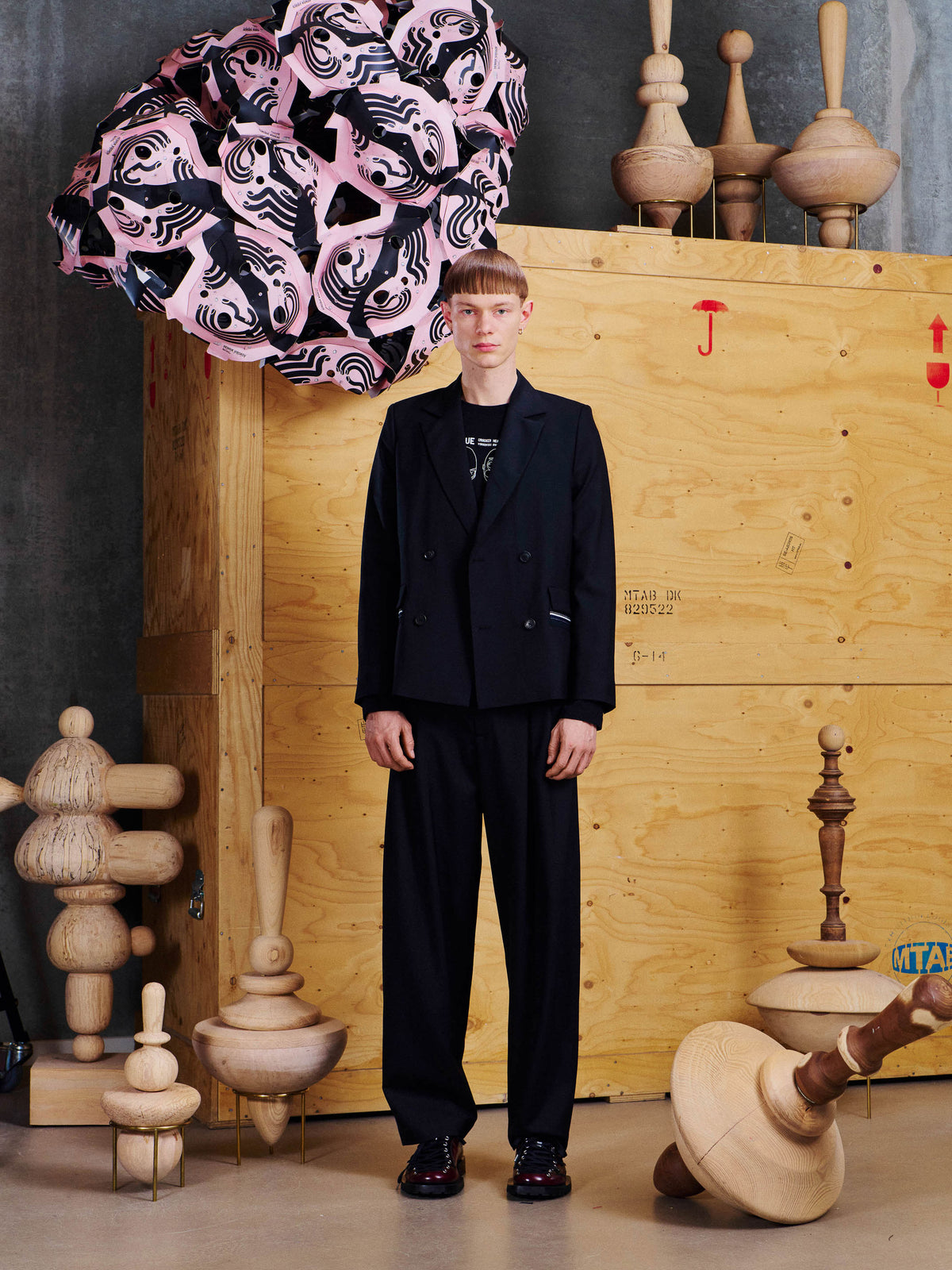 Henrik Vibskov Motif Pants in Black styled on model with matching blazer, showing relaxed tapered leg, front pleats and tailored waistband. ID: ARCHIVE-M514