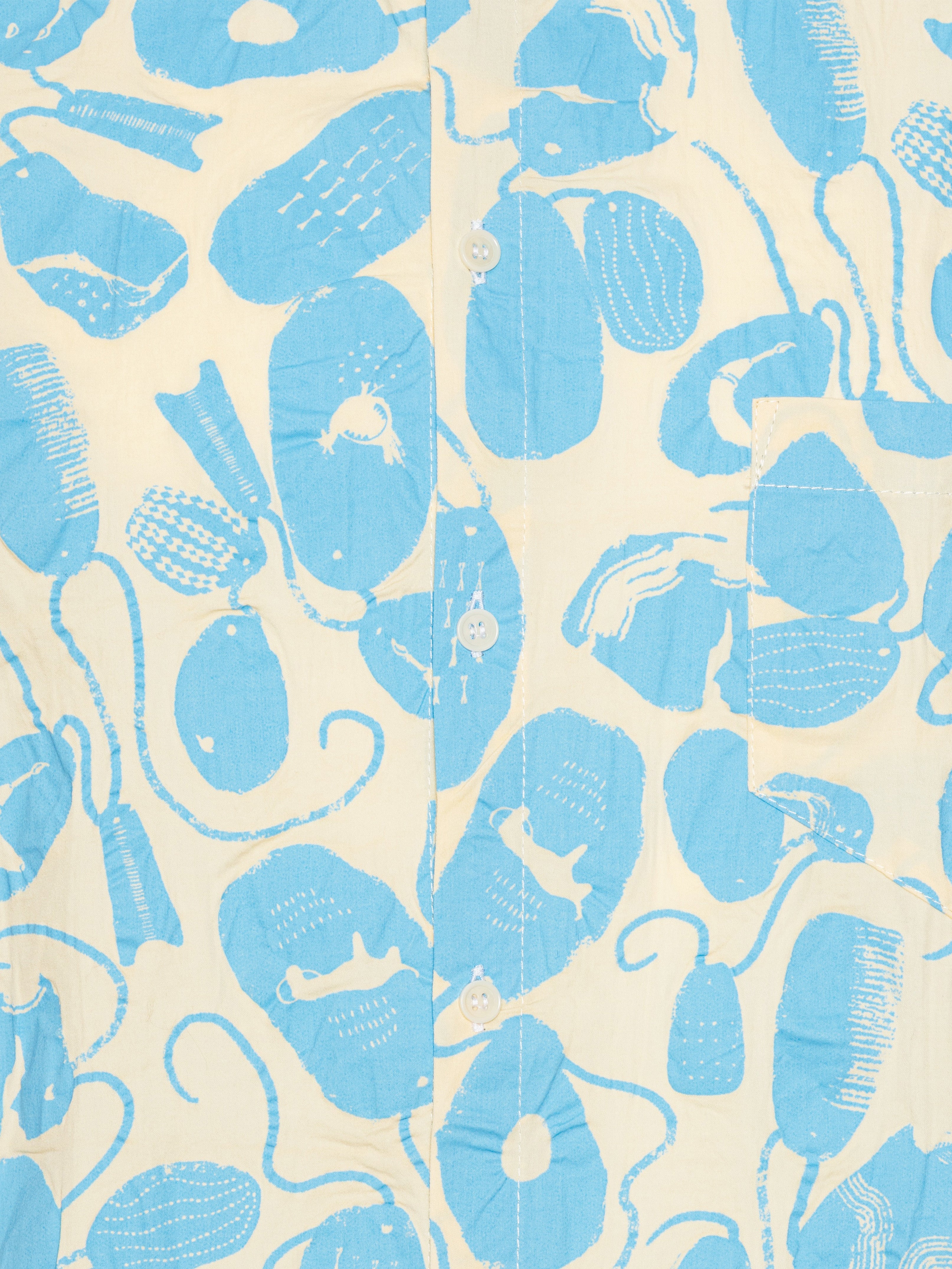 Close-up of the Henrik Vibskov New Blou Shirt in Ecru Amulets, highlighting the blue amulets pattern, button placket, and fabric texture.