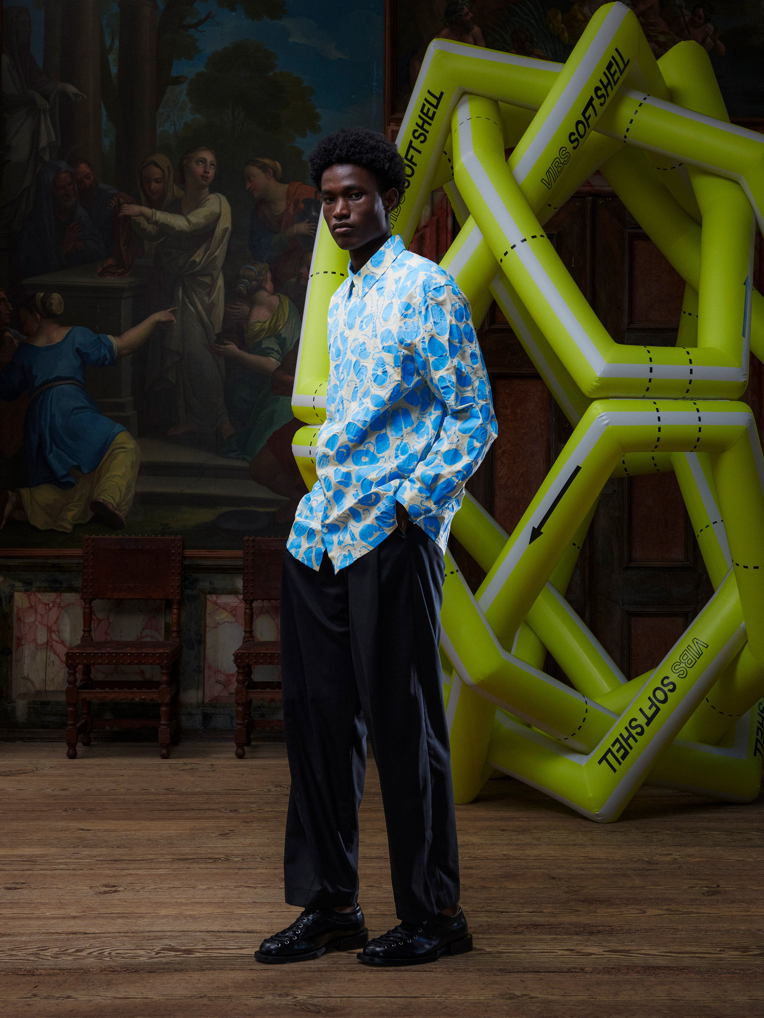 Model wearing the Henrik Vibskov New Blou Shirt in Ecru Amulets, side view, showing the long sleeves, straight hem, and all-over amulets pattern.