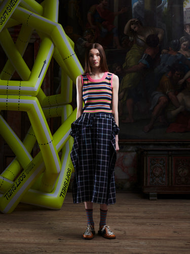 Model wearing the Henrik Vibskov Ocu Skirt in Black Checks, front view. The model is 185 cm and wears size S, showing the check pattern, extra fabric design, and side slit.