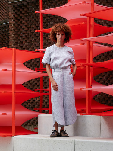 Model wearing Henrik Vibskov Overlap Pants in grey with wide-leg fit and relaxed silhouette, shown from the front.