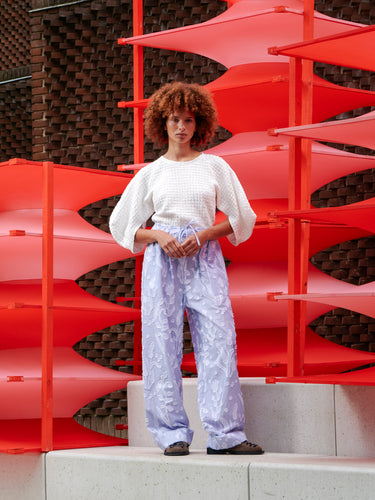 Model wearing the off-white Persey Top, front view, showing cropped hem and sculptural puffy sleeves.